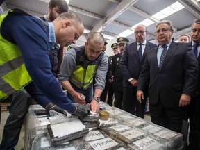 A handout picture released by the Spanish interior ministry shows Spanish Interior Minister Juan Ignacio Zoido (second from right) inspecting packages containing cocaine after 8.7 tonnes of drugs were seized by Spanish authorities in the southern port city of Algeciras on April 25, 2018. (AFP PHOTO / SPANISH INTERIOR MINISTRY)