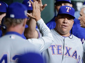 Texas Rangers starting pitcher Bartolo Guzman collects high fives in the dugout after pitching eight innings against the Houston Astros during a baseball game on April 15, 2018