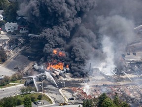 Smoke rises from railway cars that were carrying crude oil after derailing in downtown Lac-MÃ©gantic, Que., Saturday, July 6, 2013. The railway at the heart of the Lac-Megantic tragedy five years ago will not stand trial. THE CANADIAN PRESS/Paul Chiasson