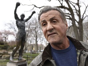 Sylvester Stallone talks to reports in front of the Rocky statue for a "Creed II" photo op, Friday, April 6, 2018, in Philadelphia.