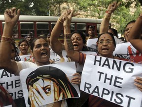 FILE - In this Aug 23, 2013 file photo, Indian activists hold placards demanding rapists be hanged as they protest against the gang rape of a 22-year-old woman photojournalist in Mumbai India. India's government has decided to prescribe the death penalty for people convicted of raping girls under the age of 12 to combat an increase in crimes against women. The Press Trust of India news agency reported Saturday, April 21, 2018, that the ordinance is being sent to the president for approval. It will require the approval of Parliament within six months in order the become law.