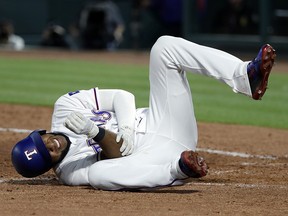 Texas Rangers' Elvis Andrus rolls on the ground after being hit by a pitch from Los Angeles Angels' Keynan Middleton in Arlington, Texas, Wednesday April 11, 2018. (AP Photo/Tony Gutierrez)