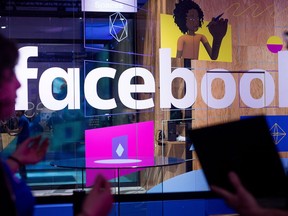 In this April 18, 2017, file photo, conference workers speak in front of a demo booth at Facebook's annual F8 developer conference, in San Jose, Calif.