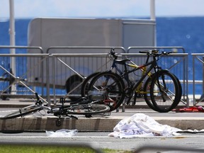 Bicycles, a shoe and sheets lay at the scene where a truck mowed through revelers in Nice, southern France, Friday, July 15, 2016. A large truck mowed through revelers gathered for Bastille Day fireworks in Nice, killing more than 80 people and sending people fleeing into the sea as it bore down for more than a mile along the Riviera city's famed waterfront promenade. (AP Photo/Francois Mori)