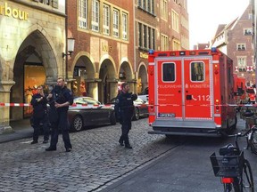 Firefighters stand in downtown Muenster, Germany, Saturday, April 7, 2018. German news agency dpa says several people were killed after car crashes into crowd in city of Muenster.  (dpa via AP)