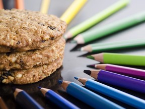 This stock photo shows cookies surrounded by coloured pencils.