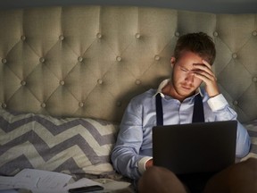 Businessman At Home On Bed Working Late On Laptop