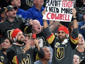 Vegas Golden Knights fans hold up a cowbell and a sign during Game 1 of the Western Conference first-round series against the Los Angeles Kings at T-Mobile Arena on April 11, 2018