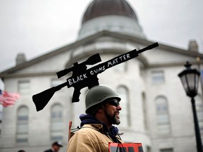 Joe Dobbins of Hartford, Maine, wears a cut-out of an AR-10 tactical rifle while attending a gun rights rally, Saturday, April 14, 2018, at the State House in Augusta, Maine.  (AP Photo/Robert F. Bukaty)