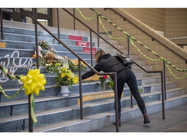 A woman lays flowers at a memorial on the stairs leading into Elgar Petersen Arena, home of the Humboldt Broncos hockey team, in Humboldt, Sask., on Saturday, April 7, 2018. RCMP say 14 people are dead and 14 people were injured Friday after a truck collided with a bus carrying a junior hockey team to a playoff game in northeastern Saskatchewan. Police say there were 28 people including the driver on board the Humboldt Broncos bus when the crash occurred at around 5 p.m. on Highway 35 north of Tisdale.