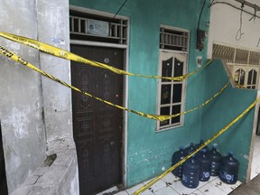 Police tape covers a home-based alcohol factory in Jakarta, Indonesia, Monday, April 9, 2018. Nearly 50 people have died in a little more than a week after drinking bootleg liquor in western Indonesia, including Jakarta, the capital, officials said Monday.