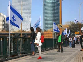 People stand still as a two-minute silence in memory of victims of the Holocaust in Tel Aviv, Israel, Thursday, April 12, 2018.