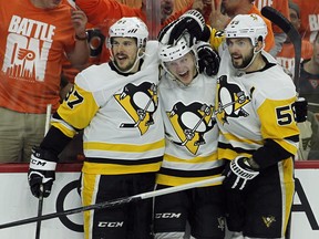 From left to right, Pittsburgh Penguins' Sidney Crosby, Jake Guentzel and Kris Letang celebrate Guentzels' goal during the third period in Game 6 of an NHL first-round hockey playoff series Sunday, April 22, 2018, in Philadelphia. (AP Photo/Tom Mihalek)