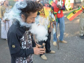 In this Feb. 6, 2013 photo, a Rastafarian named Bongho Jatusy smokes a pipe of marijuana outside a museum dedicated to the memory of late reggae icon Bob Marley in Kingston, Jamaica.