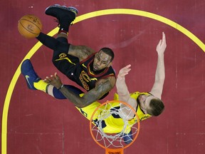 Cleveland Cavaliers' LeBron James, left, drives to the basket against Indiana Pacers' Domantas Sabonis, from Lithuania, in the first half of Game 5 of an NBA basketball first-round playoff series on April 25, 2018