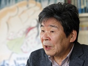 In this Feb. 12, 2015 photo, Japanese animated film director Isao Takahata speaks about his latest film "The Tale of The Princess Kaguya" with its poster during an interview at his office, Studio Ghibli, in suburban Tokyo. (AP Photo/Shizuo Kambayashi, File)