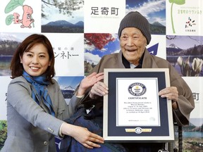 Masazou Nonaka, right, receives the certificate from Guinness World Records as the world's oldest living man at age 112 years and 259 days during a ceremony in Ashoro on Japan's northern main island of Hokkaido.
