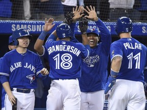 Toronto Blue Jays designated hitter Curtis Granderson (18) celebrates his grand slam off of Kansas City Royals relief pitcher Justin Grimm (52) with teammate Toronto Blue Jays starting pitcher Marcus Stroman (6) during eighth inning AL baseball action in Toronto on Wednesday, April 18, 2018. Jays centre fielder Kevin Pillar (11), shortstop Aledmys Diaz (1) and catcher Luke Maile (21) scored on the play. THE CANADIAN PRESS/Nathan Denette