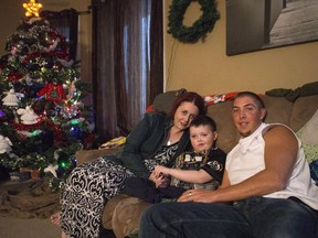 Evan Leversage, centre, sits in his family home with mother Nicole Wellwood, left, and father Travis Leversage before watching a Christmas Parade in St. George, Ont., on October 24, 2015. A Canadian woman will be heading to India to watch the premiere of a film inspired by the story of her son, whose terminal illness moved a small Ontario town to give the seven-year-old a last Christmas. The town of St. George, Ont., came together to in October 2015 to throw a parade -- complete with artificial snow and Santa Claus -- for Evan Leversage, who had asked his mother for one last Christmas as he had an inoperable brain tumour. His mother, Nicole Wellwood, worried her boy wouldn't live until late December. He died on Dec. 6, 2015.