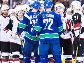 Vancouver Canucks' Henrik Sedin (33) and his twin brother Daniel Sedin (22), both of Sweden, shake hands with Arizona Coyotes players after defeating them 4-3 in their final NHL hockey home game, in Vancouver on Thursday, April 5, 2018. (CP)