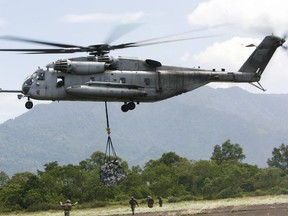 In this Saturday Oct. 10, 2009, file photo, a U.S. military helicopter, the CH-53E Super Stallion, airlifts humanitarian aid to be dropped in affected regions around Pariaman, north of Padang, Indonesia. (AP Photo/Wong Maye-E, File)