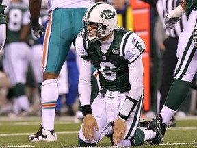 Mark Sanchez of the New York Jets picks himself up after an incomplete pass against the Miami Dolphins at New Meadowlands Stadium on December 12, 2010 in East Rutherford, New Jersey.