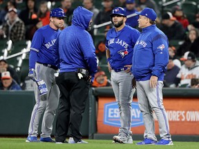 Kendrys Morales of the Toronto Blue Jays talks with a trainer, first base coach Tim Leiper and manager John Gibbons at Oriole Park at Camden Yards on April 9, 2018 in Baltimore. (Rob Carr/Getty Images)