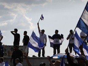 People, many who demand Nicaraguan President Daniel Ortega and his wife, Vice-President Rosario Murillo, to step down, take part in the "Walk for Peace and Dialogue" in Managua on April 23, 2018