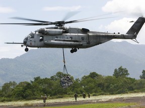 In this Saturday Oct. 10, 2009, file photo, a U.S. military helicopter, the CH-53E Super Stallion, airlifts humanitarian aid to be dropped in affected regions around Pariaman, north of Padang, Indonesia.  (AP Photo/Wong Maye-E, File)
