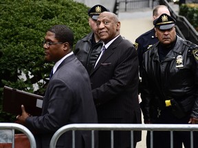 Bill Cosby, center, leaves his sexual assault trial with spokesperson Andrew Wyatt, left, at the Montgomery County Courthouse, Monday, April 9, 2018, in Norristown, Pa. Cosby paid nearly $3.4 million to the woman he is charged with sexually assaulting, a prosecutor revealed to jurors Monday, answering one of the biggest questions surrounding the case as the comedian's retrial got underway.