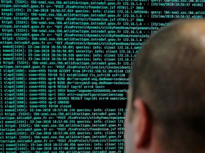 In this Jan.23 2018 file photo, a French solider watches code lines on his computer at the French Defense ministry stand during the International Cybersecurity forum in Lille, northern France.