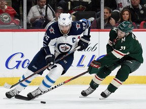 Zach Parise of the Minnesota Wild reaches for the puck against Blake Wheeler of the Winnipeg Jets during Game 3 at Xcel Energy Center on April 15, 2018 in St Paul, Minnesota. (Hannah Foslien/Getty Images)