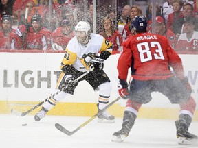 Pittsburgh Penguins right wing Phil Kessel (81) skates with the puck as is shavings are sprayed, while Washington Capitals center Jay Beagle (83) watches during the first period of Game 1 of an NHL hockey second-round playoff series Thursday, April 26, 2018, in Washington.