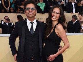 FILE - In this Jan. 21, 2018, file photo, John Stamos, left, and Caitlin McHugh arrive at the 24th annual Screen Actors Guild Awards at the Shrine Auditorium & Expo Hall in Los Angeles. Stamos announced on Instagram the birth of his son, Billy Stamos.
