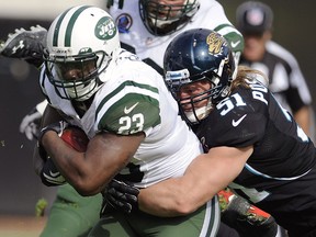 New York Jets running back Shonn Greene (23) is tackled by Jacksonville Jaguars middle linebacker Paul Posluszny (51) Sunday, Dec. 9, 2012, in Jacksonville, Fla. (AP Photo/Stephen Morton)