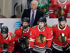 Chicago Blackhawks head coach Joel Quenneville, top, talks to his team during the third period of an NHL hockey game against the Edmonton Oilers on Jan. 7, 2018