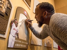 Vladimir Guerrero signs the spot where his Baseball Hall of Fame plaque will hang during a visit to the hall on April 26, 2018, in Cooperstown, N.Y.