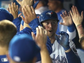 Justin Smoak of the Toronto Blue Jays is congratulated by teammates in the dugout after hitting a two-run home run in the seventh inning during MLB game action against the New York Yankees at Rogers Centre on April 1, 2018 in Toronto. (Tom Szczerbowski/Getty Images)