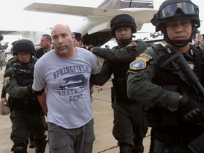 In this Sept. 26, 2013 file photo, Joseph Hunter, second from left, a former U.S. Army sniper who became a private mercenary, is in the custody of Thai police commandos after being arrested in Bangkok, Thailand.