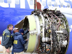 In this National Transportation Safety Board handout, NTSB investigators examine damage to the engine belonging Southwest Airlines Flight 1380 that separated during flight at Philadelphia International Airport April 17, 2018. (Keith Holloway/National Transportation Safety Board via Getty Images)