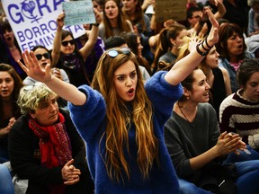 A woman holds up her arms during a protest in front of the Regional Court in Pamplona, northern Spain, Friday, April 27, 2018.