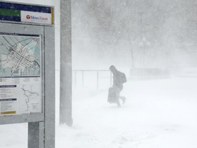 A traveler walks through the snow and ice to get to the Metro Government Center Plaza station as the snow picked up in downtown Minneapolis, Saturday, April 14, 2018. The National Weather Service predicts 9 to 15 inches of snow across a large swath of southern Minnesota including the Twin Cities before it's all over. (Anthony Souffle/Star Tribune via AP) ORG XMIT: MNMIT504