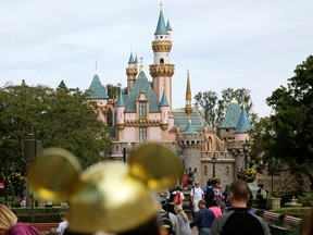 In this Jan. 22, 2015 file photo, visitors walk toward Sleeping Beauty's Castle at Disneyland Resort in Anaheim, Calif.