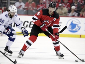 New Jersey Devils left wing Taylor Hall (9) skates with Tampa Bay Lightning right wing Nikita Kucherov (86) in tow during , Wednesday, April 18, 2018, in Newark, N.J. (AP Photo/Julio Cortez)