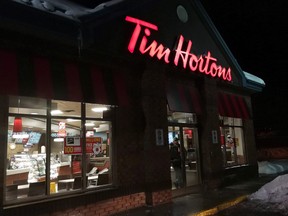 A customer walks out of a Tim Hortons restaurant in Newcastle, Ont., on Sunday Feb. 11, 2018. THE CANADIAN PRESS/Doug Ives