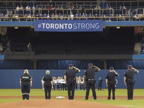 First responders who helped during Monday's deadly van rampage participate in the singing of the national anthem prior to the start of the Blue Jays game against the Boston Red Sox in Toronto on Tuesday April 24, 2018. (THE CANADIAN PRESS/Fred Thornhill)