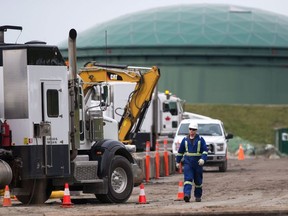 A worker walks past heavy equipment as work continues at Kinder Morgan's facility in preparation for the expansion of the Trans Mountain Pipeline, in Burnaby, B.C., on Monday April 9, 2018.