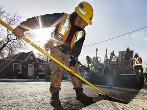 Ian Goncalves of Brantco Construction moves asphalt around a storm drain on Monday November 27, 2017 as paving commenced on the reconstruction project on Elgin Street in Brantford, Ontario which began in mid-August. Sidewalks have been added to the golf course side of the street, along with bump-outs at intersections to provide a safer thoroughfare for traffic, and a more residential look the the neighbourhood. The project is expected to be completed in the next few weeks. Brian Thompson/Brantford Expositor/Postmedia Network