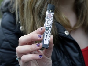 In this Wednesday, April 11, 2018 photo, an unidentified 15-year-old high school student displays a vaping device near the school's campus in Cambridge, Mass. (AP Photo/Steven Senne)