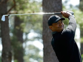 In this April 5, 2018, file photo, Tiger Woods hits a shot on the fourth hole during the first round at the Masters golf tournament in Augusta, Ga.